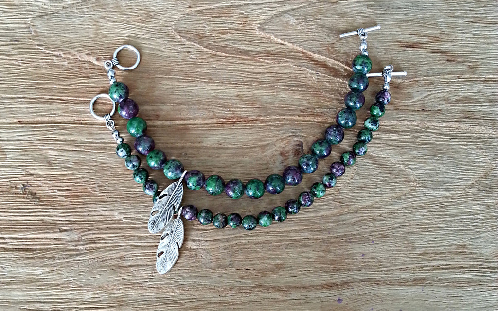Comparison view II of 8mm and 6mm ruby zoisite beads with silver feather charm bead bracelets